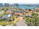 Aerial view of a waterfront home with a screened-in pool and tropical landscaping in a coastal community at 1141 80Th Street S Ct, St Petersburg, FL 33707