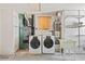 A laundry room with a washer, dryer, utility sink, and water heater at 1141 80Th Street S Ct, St Petersburg, FL 33707
