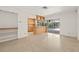 Bright living room with Terrazzo floors, sliding glass doors leading to a screened-in lanai, and kitchen view at 1141 80Th Street S Ct, St Petersburg, FL 33707