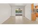 Bright living room with terrazzo flooring and sliding glass doors leading to a screened-in pool and lush backyard at 1141 80Th Street S Ct, St Petersburg, FL 33707