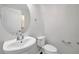 Bright powder room featuring a pedestal sink, toilet, and oval mirror at 11611 Mango Ridge Blvd, Seffner, FL 33584