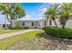 Exterior of building featuring a walkway, lush landscaping, and clear blue skies at 12400 Park Blvd # 210, Seminole, FL 33772