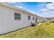 Back exterior view of a home with an AC unit, well maintained grass, and blue sky at 12400 Park Blvd # 210, Seminole, FL 33772