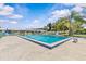 Community pool with comfortable lounge chairs under palm trees, perfect for swimming and relaxing in the sun at 12400 Park Blvd # 210, Seminole, FL 33772