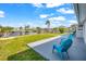 Outdoor patio with blue chairs overlooking a canal with clear blue skies, and a view of waterfront properties at 12700 5Th Isle, Hudson, FL 34667