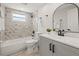Modern bathroom with marble tile, new vanity, and tub with shower at 12700 5Th Isle, Hudson, FL 34667
