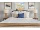Comfortable bedroom featuring a queen bed with white linens, stylish lamps, and minimalist wall decor at 12700 5Th Isle, Hudson, FL 34667