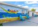Side view of a house with a vibrant mural and bright blue patio chairs creating a fun and inviting outdoor space at 12700 5Th Isle, Hudson, FL 34667