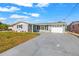 Charming single-story home with gray exterior, well-maintained lawn, and a long driveway at 12700 5Th Isle, Hudson, FL 34667