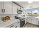 Bright white kitchen featuring modern appliances, quartz countertops, and a large window with a water view at 12700 5Th Isle, Hudson, FL 34667
