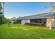 Wide view of the backyard featuring a grassy area, partial fence, and landscaping at 1300 Shady Pine Way # B, Tarpon Springs, FL 34688