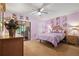 Relaxing bedroom featuring light purple walls, tile floors, a comfortable bed, and sliding door access to an outdoor area at 1300 Shady Pine Way # B, Tarpon Springs, FL 34688