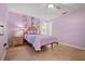 Inviting bedroom with light purple walls, a comfy bed, and tile floors at 1300 Shady Pine Way # B, Tarpon Springs, FL 34688