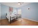 Comfortable bedroom featuring light blue walls, tile floors, and a wrought iron bed frame at 1300 Shady Pine Way # B, Tarpon Springs, FL 34688