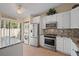 Bright kitchen featuring modern appliances and a breakfast bar, plus stacked washer/dryer at 1300 Shady Pine Way # B, Tarpon Springs, FL 34688