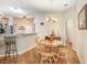 Cozy dining area features a round table, wood chairs, chandelier, and seamlessly connects to the kitchen at 13411 Graham Yarden Dr, Riverview, FL 33579