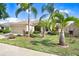 Attractive single-story home with lush landscaping, mature palm trees, and a convenient two-car garage for easy parking at 13411 Graham Yarden Dr, Riverview, FL 33579