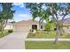 Charming single-story home with well-manicured lawn and lush landscaping, complemented by mature trees and a neutral color palette at 13411 Graham Yarden Dr, Riverview, FL 33579