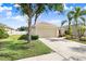 Cozy single-story home with a two-car garage, green lawn, and mature trees, creating a serene and inviting atmosphere at 13411 Graham Yarden Dr, Riverview, FL 33579