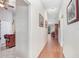 Bright hallway with hardwood floors, neutral paint, and decorative artwork on the walls, leading to the main living areas at 13411 Graham Yarden Dr, Riverview, FL 33579