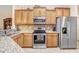 Modern kitchen with stainless steel appliances, updated cabinets, granite countertops, and stylish mosaic backsplash at 13411 Graham Yarden Dr, Riverview, FL 33579