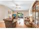 Bright living room with hardwood floors, ceiling fan, comfortable seating, and sliding glass doors to outdoor space at 13411 Graham Yarden Dr, Riverview, FL 33579