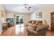 Inviting living room featuring a ceiling fan, hardwood floors, comfortable seating, and natural light from sliding glass doors at 13411 Graham Yarden Dr, Riverview, FL 33579