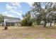 Spacious backyard with a screened-in pool area, mature trees, and room for recreation at 1350 Mustang St, Nokomis, FL 34275