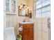 Cozy bathroom with tile walls, vanity, toilet, and a window bringing in natural light at 1350 Mustang St, Nokomis, FL 34275