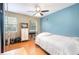 A bedroom features wood floors, a ceiling fan, and two windows with light pouring into the room at 1350 Mustang St, Nokomis, FL 34275