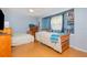 Bedroom with two beds, wood flooring, ceiling fan, and light blue walls is a comfortable and inviting space at 1350 Mustang St, Nokomis, FL 34275
