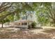 Charming home with a wide front porch surrounded by trees and landscaped flower beds at 1350 Mustang St, Nokomis, FL 34275