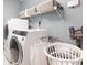 Laundry room with modern washer, dryer, shelving, and laundry basket, designed for efficiency and convenience at 1350 Mustang St, Nokomis, FL 34275