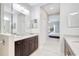 This bright bathroom features double sinks, granite counters, tile flooring and opens into a spacious bedroom at 13518 Circa Crossing Dr, Lithia, FL 33547