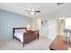 Relax in this bedroom featuring an accent wall, plush carpet, ceiling fan, and a glimpse into the bathroom at 13518 Circa Crossing Dr, Lithia, FL 33547