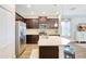 Modern kitchen with stainless steel appliances, stylish dark wood cabinets and a spacious island at 13518 Circa Crossing Dr, Lithia, FL 33547