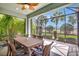 Relax on this screened lanai featuring a ceiling fan, a wooden table with seating and backyard views at 13518 Circa Crossing Dr, Lithia, FL 33547