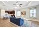 Spacious living room with adjacent kitchen featuring stainless steel appliances and bar seating at 13518 Circa Crossing Dr, Lithia, FL 33547