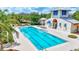 Lap pool with bright blue lines next to a modern clubhouse with lounge chairs and palm trees at 13518 Circa Crossing Dr, Lithia, FL 33547