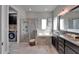 Luxurious bathroom with soaking tub, glass-enclosed shower, and dual vanity with granite countertops at 14204 Barrington Stowers Dr, Lithia, FL 33547