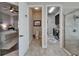 En-suite bathroom featuring modern fixtures, glass shower, toilet and view into a laundry room and main bedroom at 14204 Barrington Stowers Dr, Lithia, FL 33547