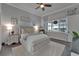 Cozy bedroom features a tufted headboard, neutral decor, and a bright window with decorative curtains at 14204 Barrington Stowers Dr, Lithia, FL 33547