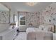 Charming bedroom with floral wallpaper, large mirror and light at 14204 Barrington Stowers Dr, Lithia, FL 33547