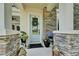 Inviting front entrance with stone pillars, a decorative wreath, and potted plants creating a warm welcome at 14204 Barrington Stowers Dr, Lithia, FL 33547