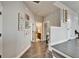 Hallway with wood floors, decorative artwork, and access to multiple rooms, including a bathroom at 14204 Barrington Stowers Dr, Lithia, FL 33547