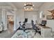 Spacious office setup with hardwood floors, exercise equipment, and an open view to the kitchen at 14204 Barrington Stowers Dr, Lithia, FL 33547