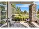Inviting porch with stone columns, garden view, and comfortable seating overlooking a beautifully landscaped lawn at 14204 Barrington Stowers Dr, Lithia, FL 33547