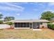 Backyard featuring a screened-in lanai and fenced yard with tropical foliage at 14330 Oliver St, Largo, FL 33774