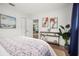 Well-lit bedroom featuring a patterned bedspread, decorative paintings, and a stylish shelving unit with a plant at 14330 Oliver St, Largo, FL 33774