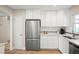 Updated kitchen with stainless steel refrigerator, white cabinets, and stylish backsplash at 14330 Oliver St, Largo, FL 33774